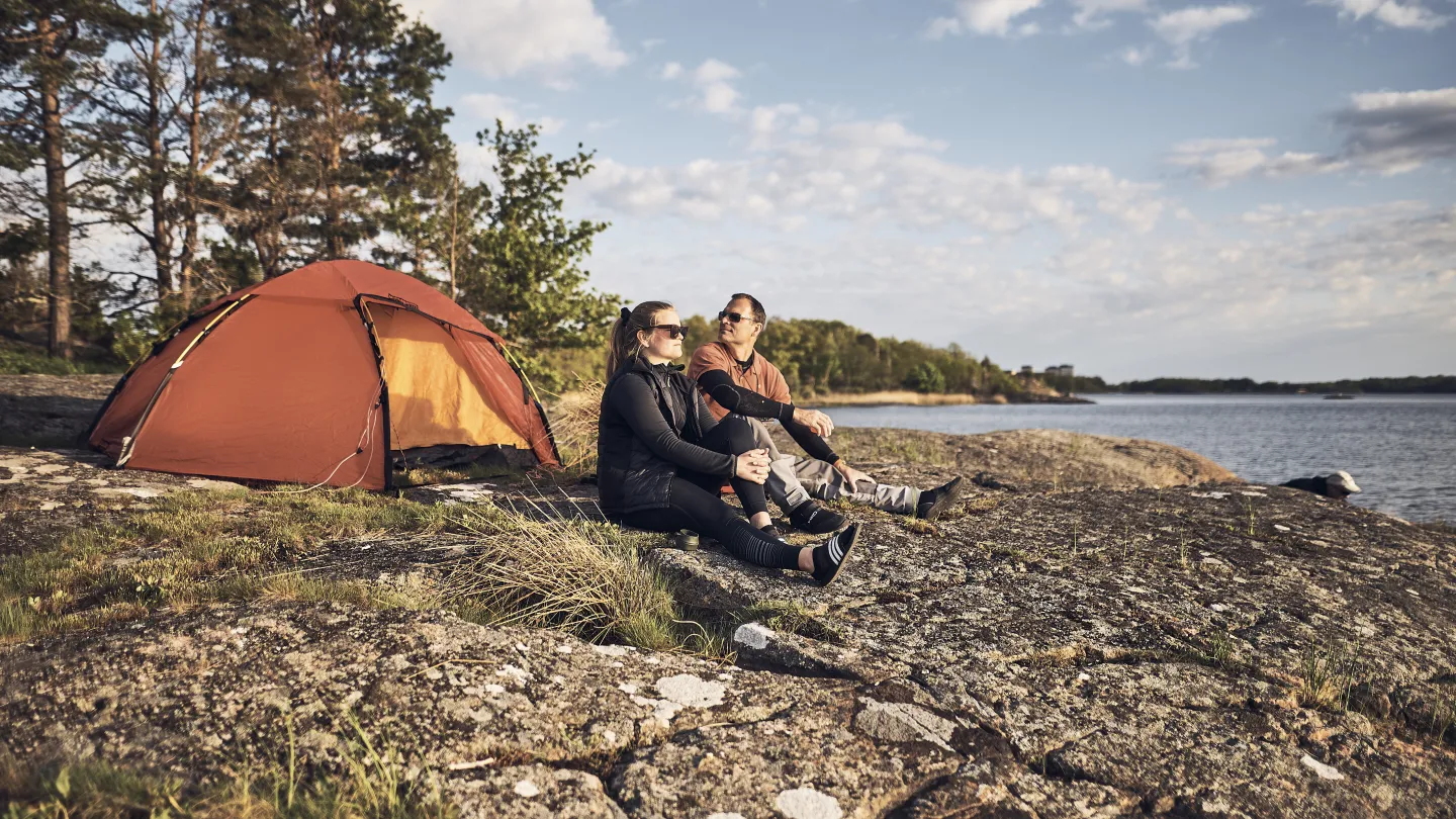 Personer framför tält i skärgården