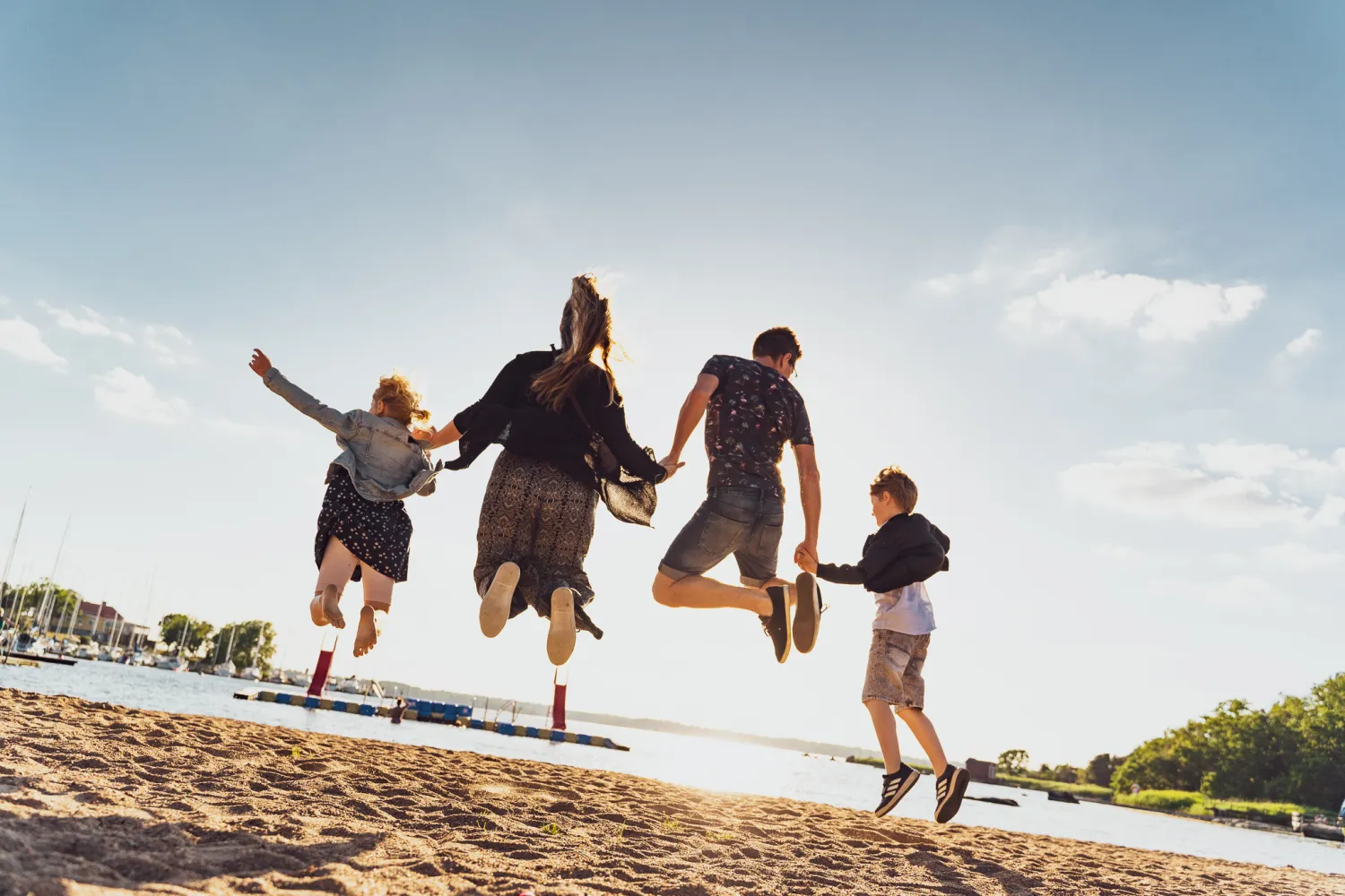 Hoppande familj på stranden