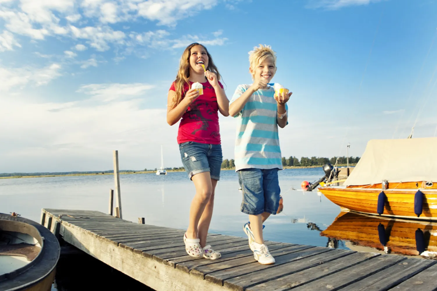 Barn som äter glass på bryggan