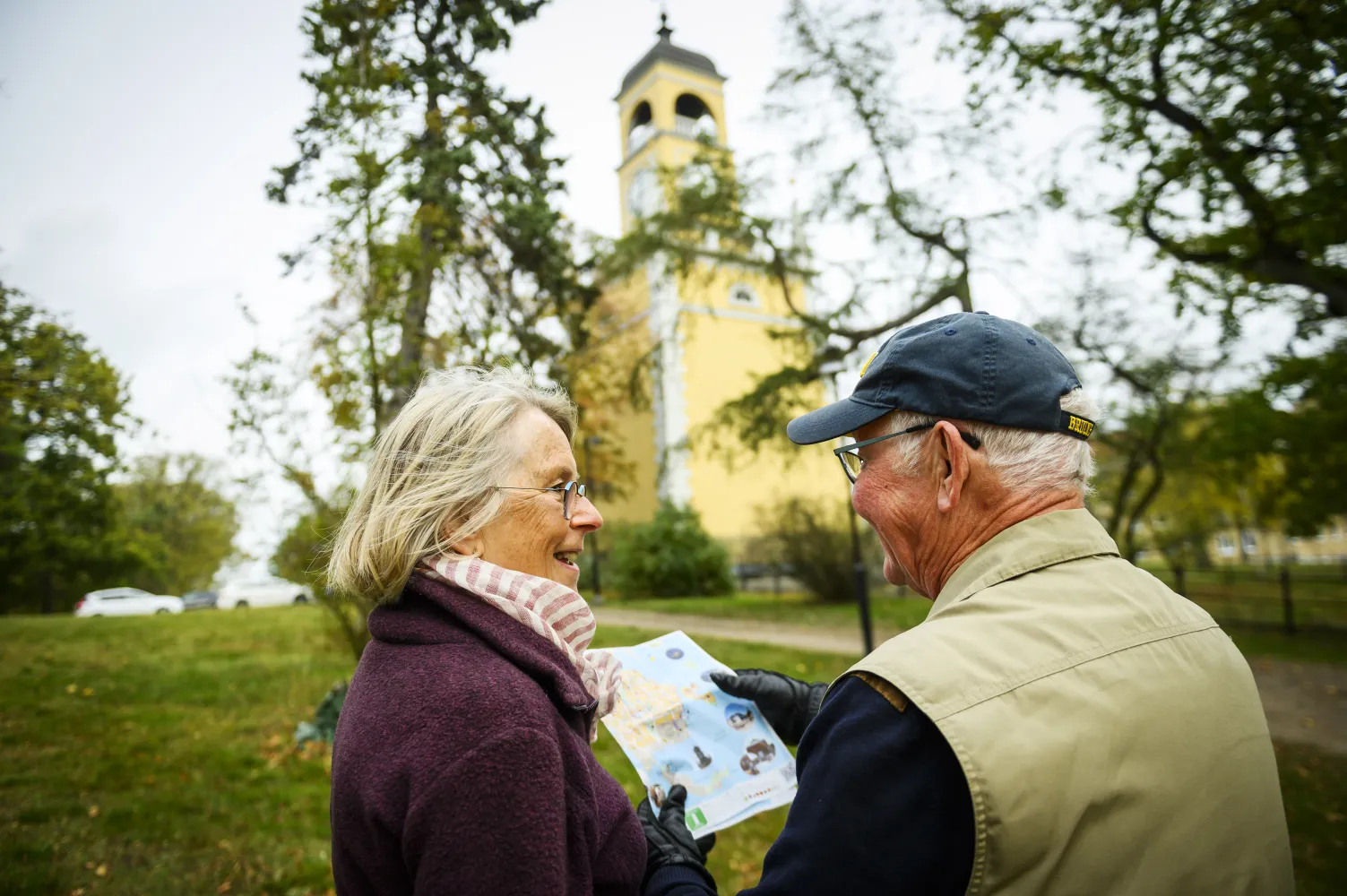 Två personer framför Klockstapeln i Amiralitetsparken