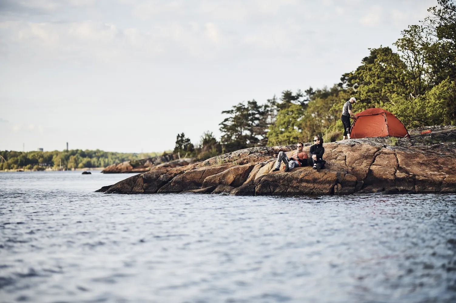 Tre personer på klippa med tält