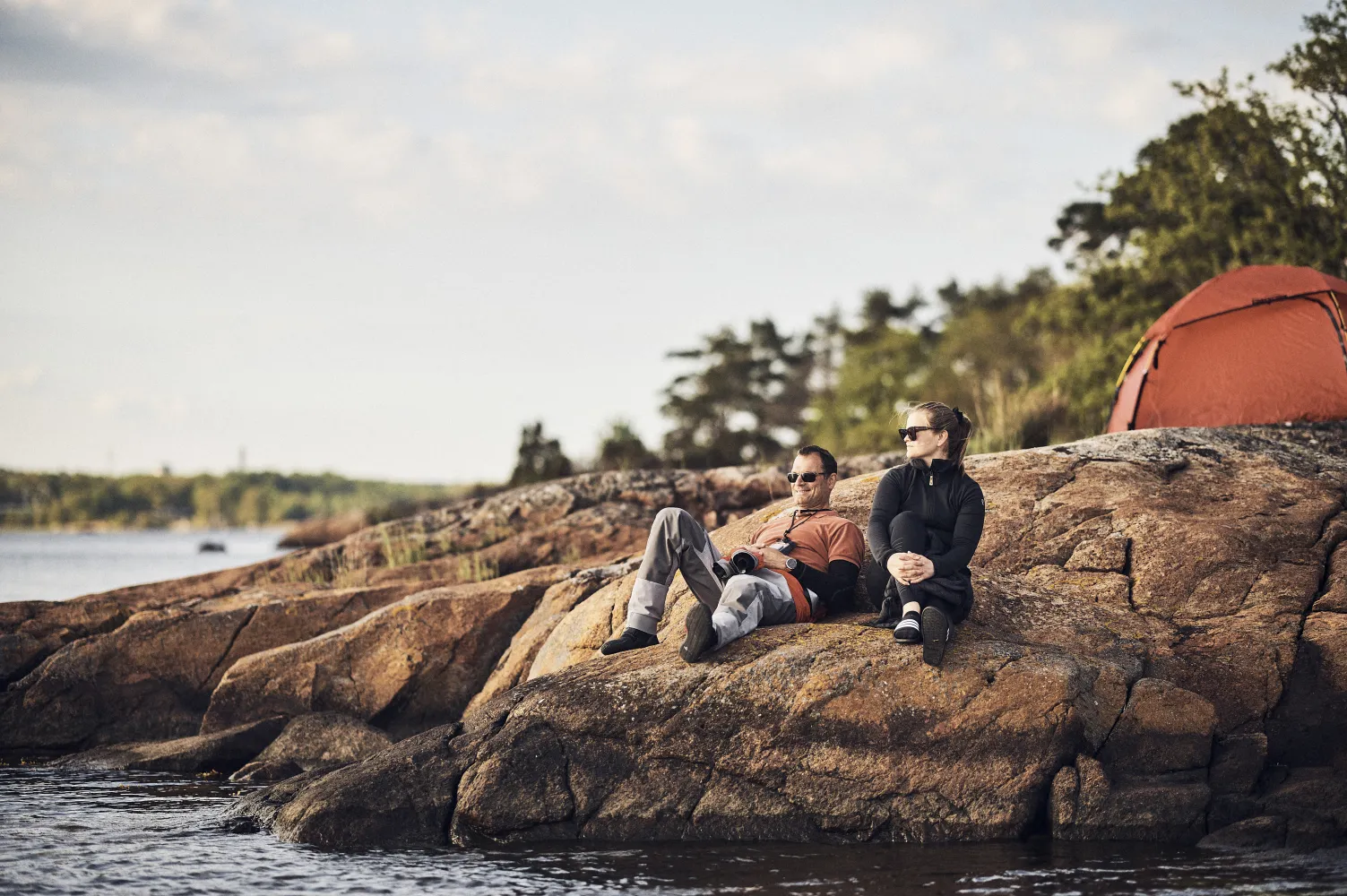 Två personer framför tält i skärgården