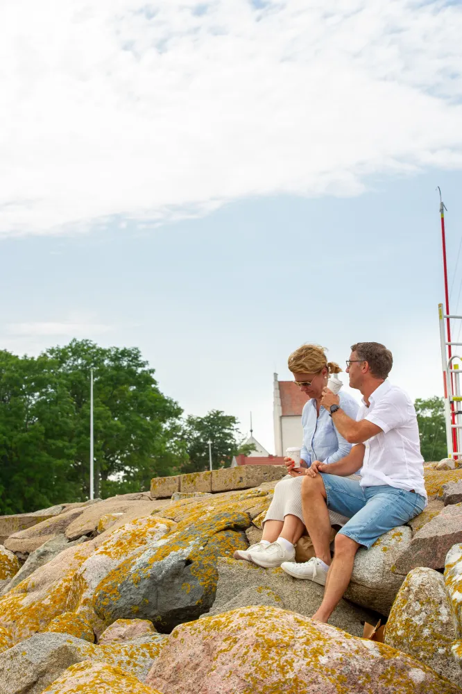 Två personer fikar vid havet