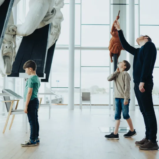 Marinmuseums galjonshall med tre besökare